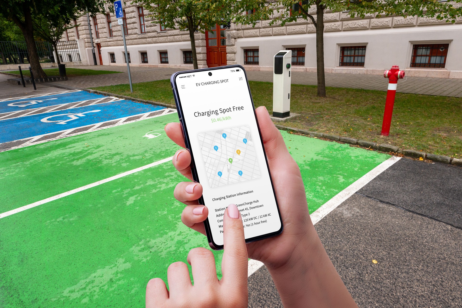 User stands in an EV charging station parking lot, holding a smartphone with a map displaying nearby charging points in the city
