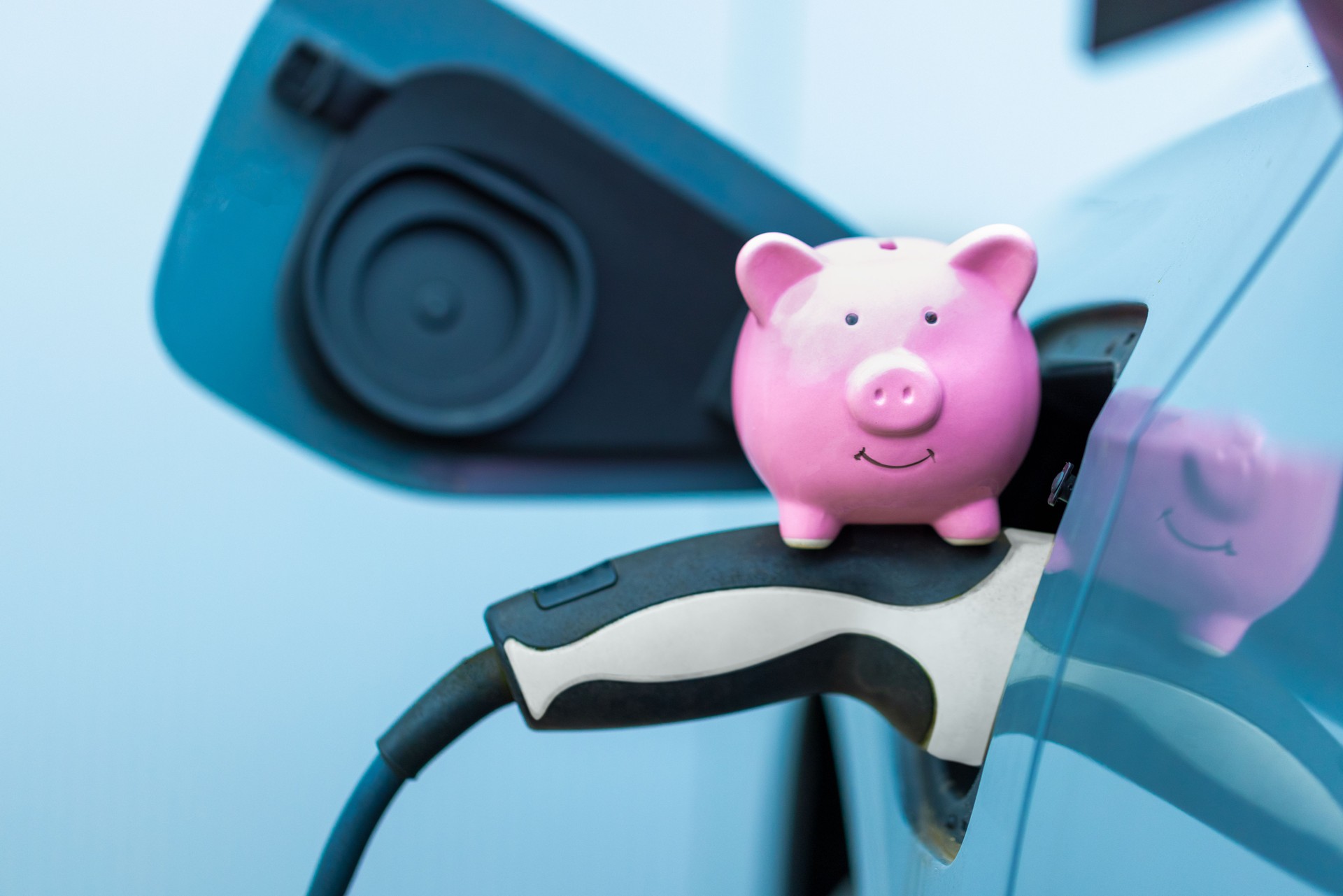 Piggy bank sits on the power plug when charging the electric vehicle