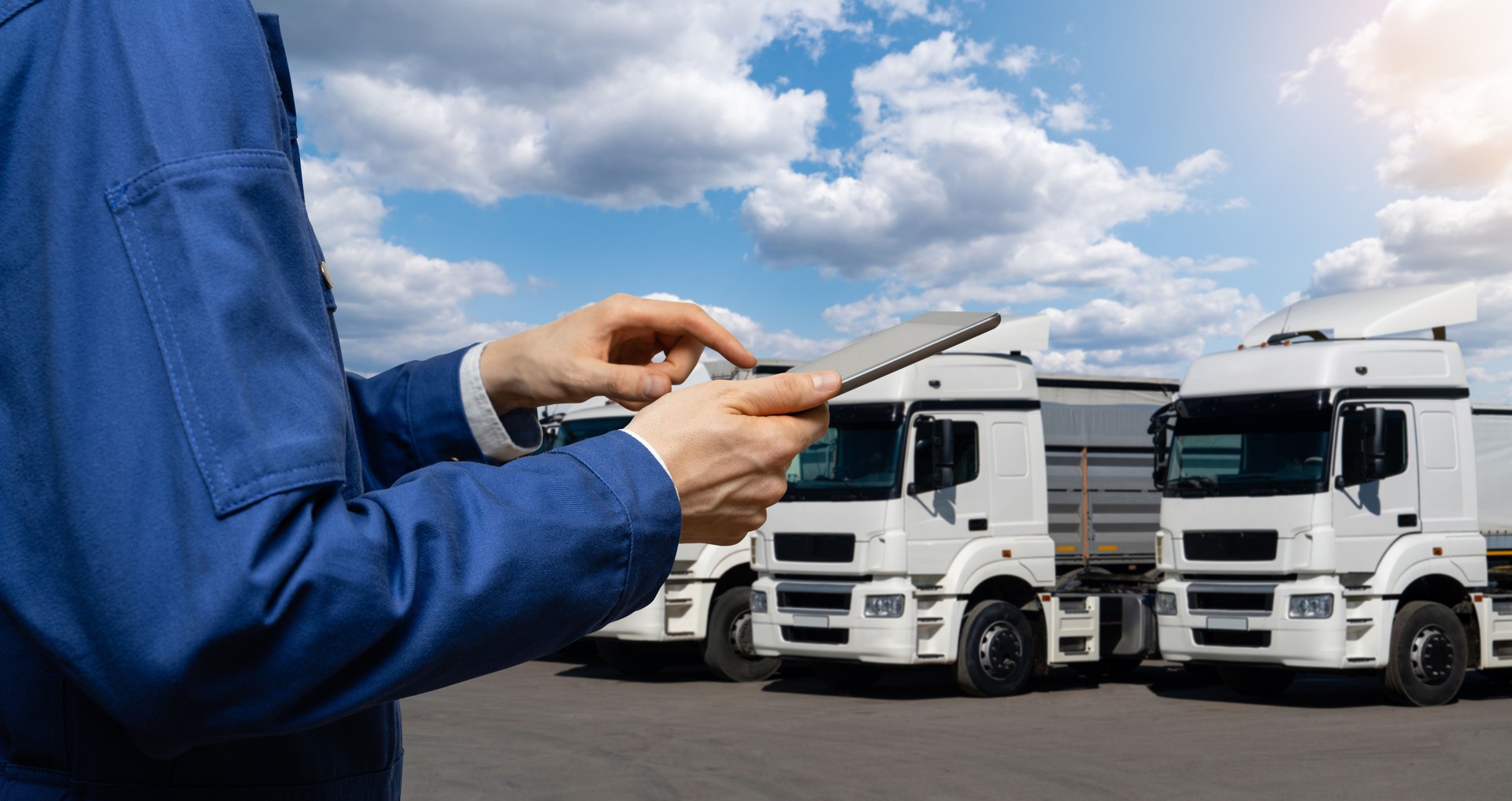 Manager with a digital tablet on the background of trucks